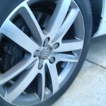 Before and after photographs of a damaged white, AUDI Quattro SUV that was repaired by Elite Paint & Body Shop in West Palm Beach, Florida.